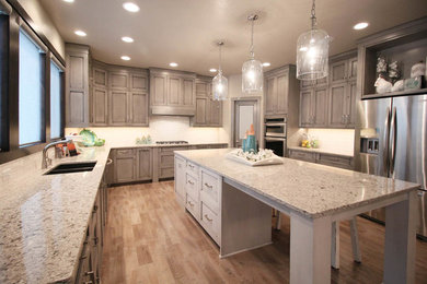 Enclosed kitchen - large contemporary u-shaped light wood floor enclosed kitchen idea in Other with a double-bowl sink, shaker cabinets, gray cabinets, quartz countertops, white backsplash, subway tile backsplash, stainless steel appliances and an island