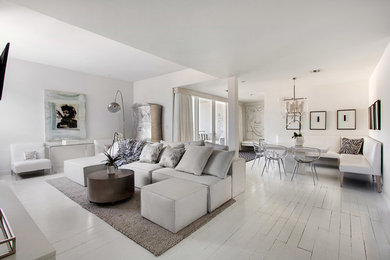 Inspiration for a mid-sized contemporary open concept painted wood floor and white floor living room remodel in New Orleans with white walls, a standard fireplace, a stone fireplace and a wall-mounted tv