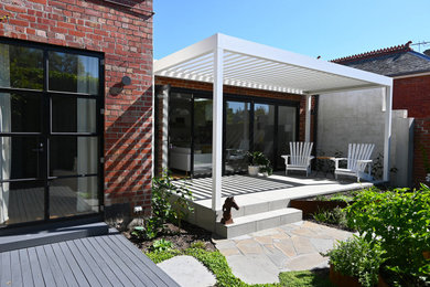 Foto de terraza planta baja bohemia de tamaño medio en patio con jardín de macetas y pérgola