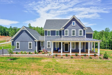 Example of a large cottage gray two-story gable roof design in Other