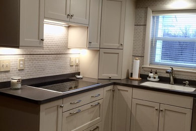 Inspiration for a mid-sized transitional u-shaped linoleum floor eat-in kitchen remodel in Other with an integrated sink, recessed-panel cabinets, white cabinets, solid surface countertops, white backsplash, ceramic backsplash, stainless steel appliances and a peninsula