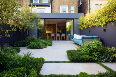 Design ideas for a small contemporary back formal partial sun garden in London with natural stone paving.