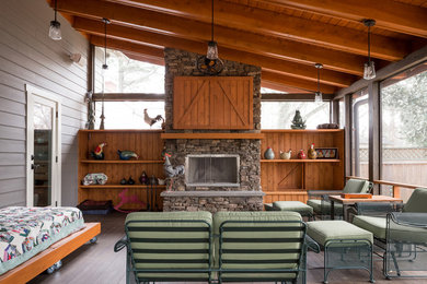 Large country stone back porch idea in Atlanta with a fire pit and a roof extension