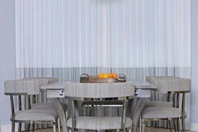 Example of a mid-sized trendy kitchen/dining room combo design in Miami with gray walls and no fireplace