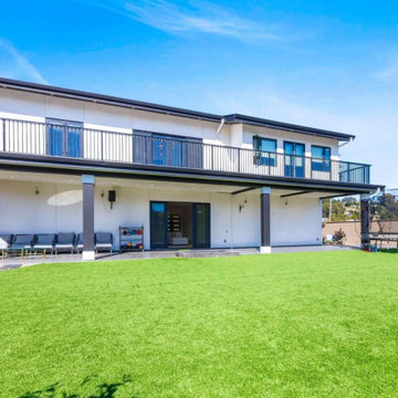 Modern Backyard Exterior with Expansive Lawn and Covered Patio