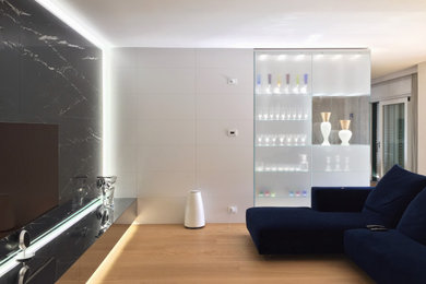 Immagine di un soggiorno contemporaneo aperto con pareti beige, parquet chiaro, TV a parete e pareti in legno