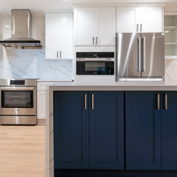 Modern White Shaker Kitchen with Navy Blue Island and Waterfall Quartz Counterto