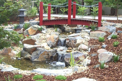 This is an example of an asian garden in Other with a water feature.