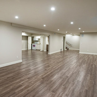 Inspiration for a large contemporary fully buried basement in Los Angeles with beige walls, medium hardwood flooring and no fireplace.