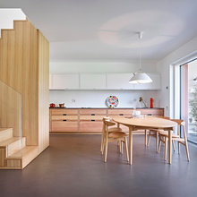 Una escalera de madera articula un ático en Italia