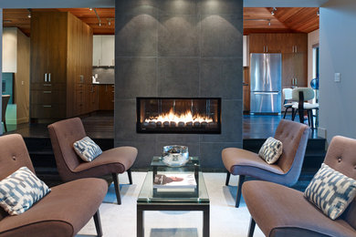 Living room - contemporary dark wood floor living room idea in Vancouver with a two-sided fireplace and a tile fireplace