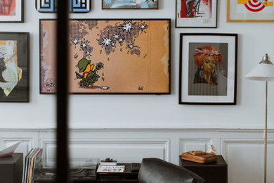 Aménagement d'un salon moderne ouvert avec un mur beige et parquet foncé.