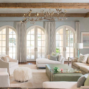 Mediterranes Wohnzimmer mit blauer Wandfarbe und dunklem Holzboden in Dallas