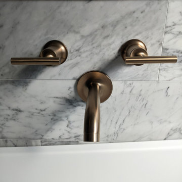 Modern primary bathroom with marble tile, curbless shower and custom vanity