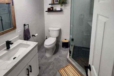 Inspiration for a mid-sized contemporary 3/4 single-sink corner shower remodel in San Diego with shaker cabinets, white cabinets, a one-piece toilet, gray walls, an undermount sink, a hinged shower door and a built-in vanity