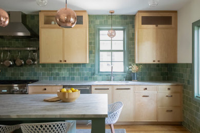 Inspiration for a mid-sized 1950s single-wall light wood floor eat-in kitchen remodel in Minneapolis with a drop-in sink, flat-panel cabinets, light wood cabinets, marble countertops, green backsplash, terra-cotta backsplash, stainless steel appliances, an island and white countertops