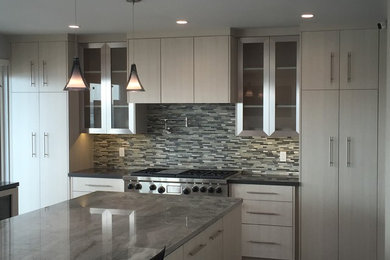 Example of a large minimalist u-shaped kitchen design in Los Angeles with flat-panel cabinets, gray cabinets and an island