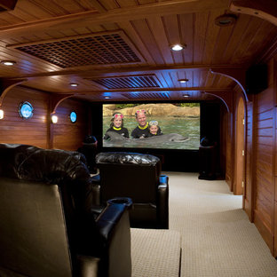 Large trendy enclosed carpeted home theater photo in Portland Maine with a projector screen