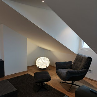 Example of a mid-sized trendy open concept light wood floor home theater design in Munich with white walls