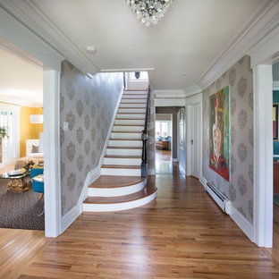 Inredning av en eklektisk mellanstor hall, med grå väggar, mellanmörkt trägolv och beiget golv