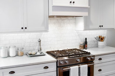 Inspiration for a mid-sized timeless u-shaped dark wood floor and brown floor enclosed kitchen remodel in Detroit with an undermount sink, shaker cabinets, white cabinets, quartz countertops, red backsplash, marble backsplash, stainless steel appliances and no island