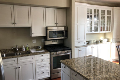 Inspiration for a mid-sized traditional eat-in kitchen in Minneapolis with a double-bowl sink, shaker cabinets, white cabinets, granite benchtops, stainless steel appliances, medium hardwood floors, with island, brown floor and grey benchtop.
