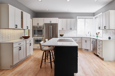 ポートランドにある高級な広いコンテンポラリースタイルのおしゃれなキッチン (アンダーカウンターシンク、シェーカースタイル扉のキャビネット、白いキャビネット、クオーツストーンカウンター、白いキッチンパネル、セラミックタイルのキッチンパネル、シルバーの調理設備、淡色無垢フローリング、マルチカラーの床、白いキッチンカウンター) の写真