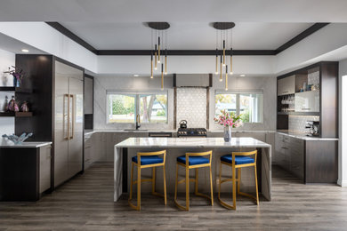 Example of a large minimalist u-shaped vinyl floor, gray floor and tray ceiling kitchen design in Detroit with an undermount sink, flat-panel cabinets, gray cabinets, quartz countertops, white backsplash, mosaic tile backsplash, an island, white countertops and paneled appliances