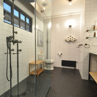 Badezimmer mit hellen Holzschränken und Granit-Waschbecken/Waschtisch