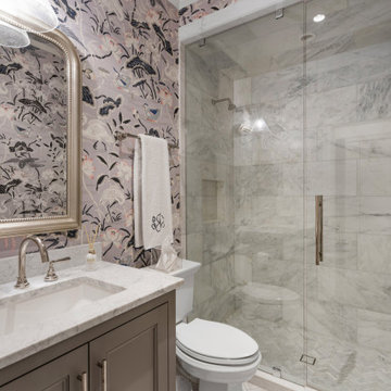 Elegant Marble Bathroom with Bold Botanical Wallpaper and Glass Shower Enclosure