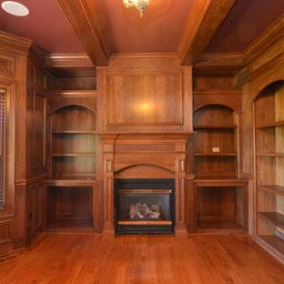 Bild på ett vintage arbetsrum, med ett bibliotek, ljust trägolv och en spiselkrans i trä