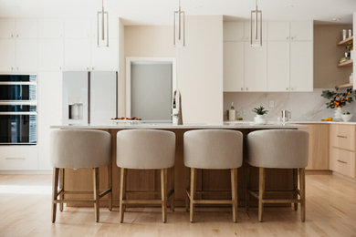 Large trendy light wood floor and yellow floor eat-in kitchen photo in Other with an undermount sink, shaker cabinets, light wood cabinets, quartz countertops, white backsplash, quartz backsplash, paneled appliances, an island and white countertops