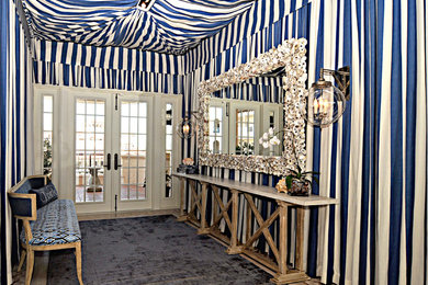 Entryway - large tropical carpeted and blue floor entryway idea in Miami with multicolored walls and a white front door