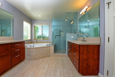 Design ideas for a mid-sized contemporary master bathroom in Los Angeles with flat-panel cabinets, dark wood cabinets, a drop-in tub, a corner shower, beige tile, stone slab, purple walls, an undermount sink, solid surface benchtops and porcelain floors.