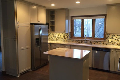 Example of a mid-sized transitional u-shaped dark wood floor and brown floor enclosed kitchen design in Minneapolis with an undermount sink, shaker cabinets, beige cabinets, quartzite countertops, multicolored backsplash, mosaic tile backsplash, stainless steel appliances, an island and beige countertops