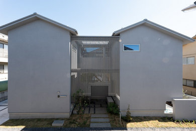 Diseño de fachada de casa gris y gris moderna de tamaño medio de dos plantas con revestimiento de estuco, tejado a dos aguas y tejado de metal