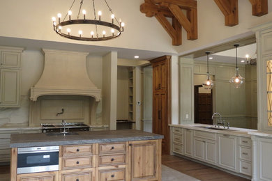 Example of a mid-sized classic u-shaped marble floor and white floor enclosed kitchen design in Other with an undermount sink, raised-panel cabinets, white cabinets, marble countertops, white backsplash, marble backsplash, stainless steel appliances and an island