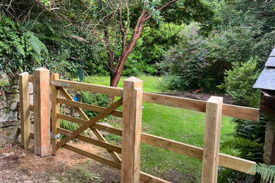 Rustic side garden in Cornwall with a wood fence.