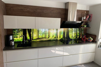 Moderne Küche mit beleuchteter Glasrückwand