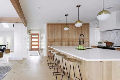 Inspiration for a mid-sized transitional single-wall kitchen pantry in Miami with an undermount sink, flat-panel cabinets, light wood cabinets, quartzite benchtops, white splashback, marble splashback, stainless steel appliances, light hardwood floors, with island, beige floor and white benchtop.