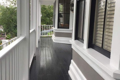 This is an example of a large traditional front porch design in Boston with decking and a roof extension.
