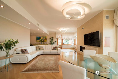 Geräumiges, Offenes Modernes Wohnzimmer mit beiger Wandfarbe, braunem Holzboden, TV-Wand und braunem Boden in Sonstige