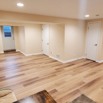 Fully remodeled 1970s finished basement with luxury vinyl plank flooring and can