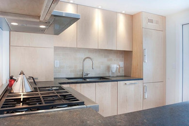 Example of a minimalist u-shaped kitchen design in Burlington with flat-panel cabinets, light wood cabinets and granite countertops
