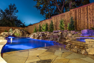 This is an example of a small tropical backyard custom-shaped natural pool in Dallas with a water feature.