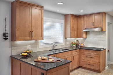 Inspiration for a mid-sized transitional u-shaped ceramic tile and multicolored floor eat-in kitchen remodel in Edmonton with an undermount sink, shaker cabinets, light wood cabinets, granite countertops, gray backsplash, ceramic backsplash, stainless steel appliances, a peninsula and black countertops