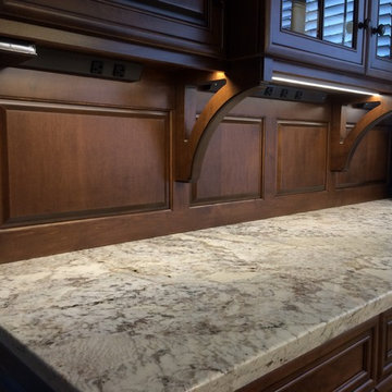 Raised panel wood backsplash and concealed power strips