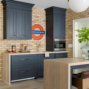 Inspiration för mellanstora klassiska parallella beige hemmabarer med stolar, med skåp i shakerstil, brunt golv, en undermonterad diskho, blå skåp och klinkergolv i porslin