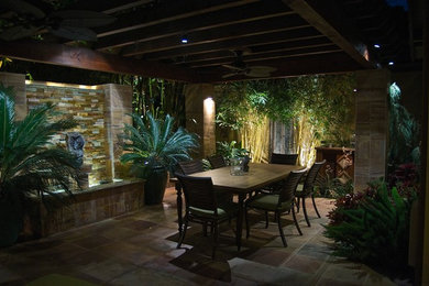Inspiration for a large tropical backyard shaded outdoor sport court in Orange County with concrete pavers.