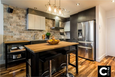 Kitchen - industrial dark wood floor kitchen idea in Montreal with an undermount sink, flat-panel cabinets, dark wood cabinets, granite countertops, gray backsplash, ceramic backsplash, stainless steel appliances and two islands